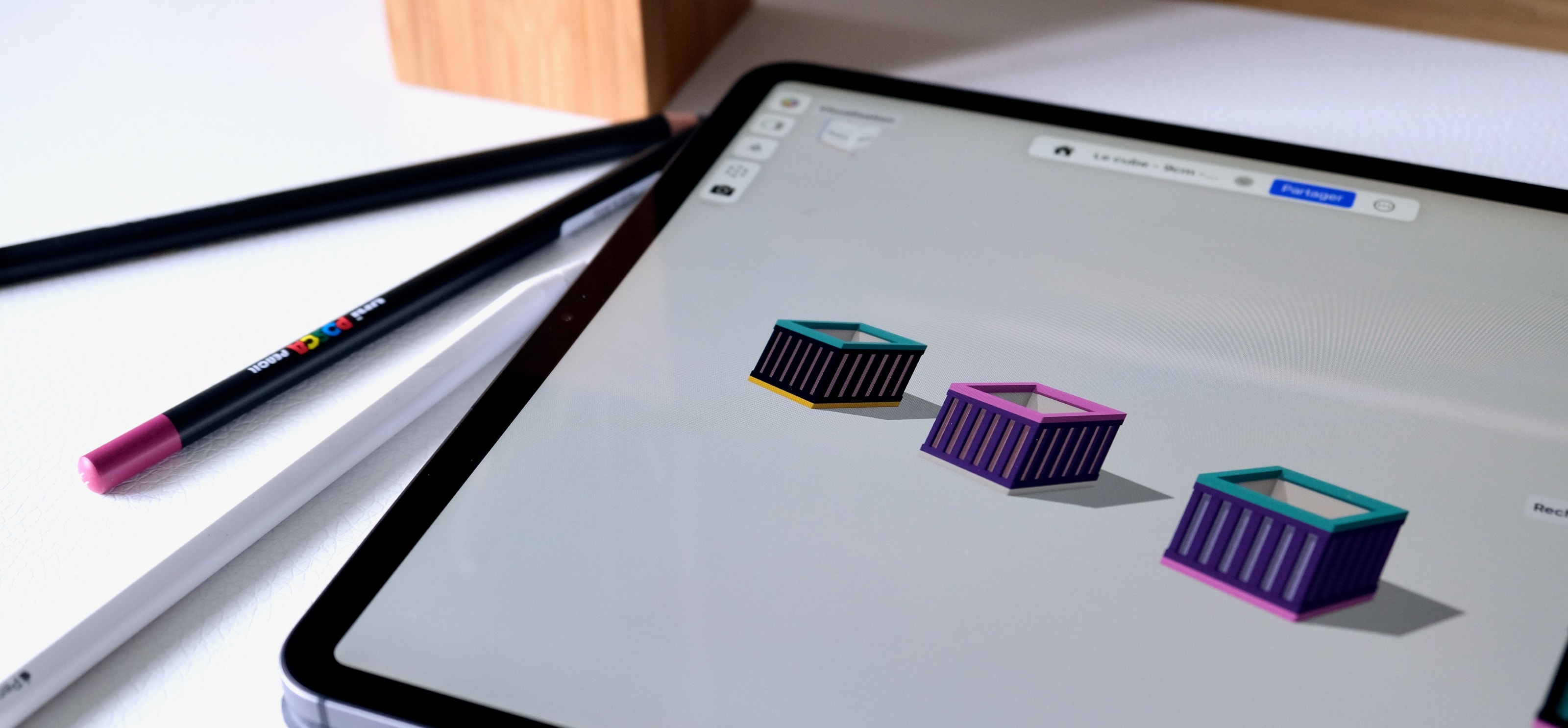 Trois modèles du Cube en cours de conception sur une tablette, à l’atelier