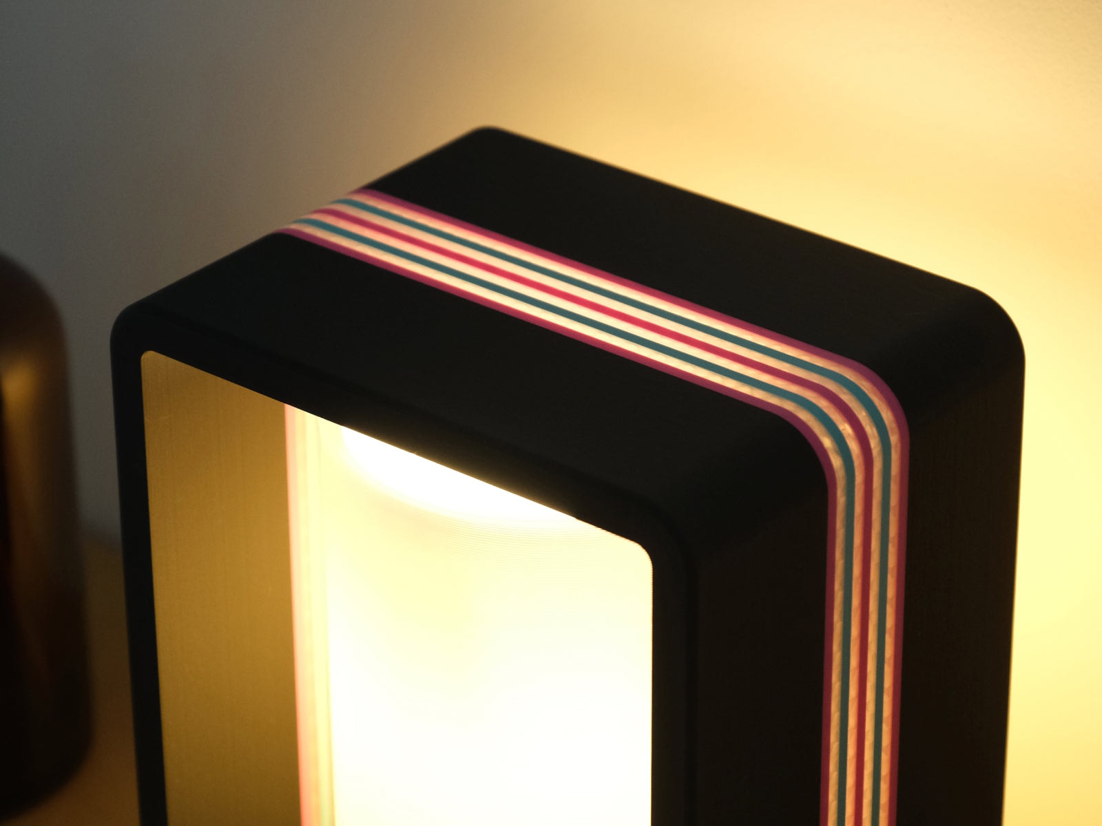 The Interstice lamp lit, warm light filtered through its ribs